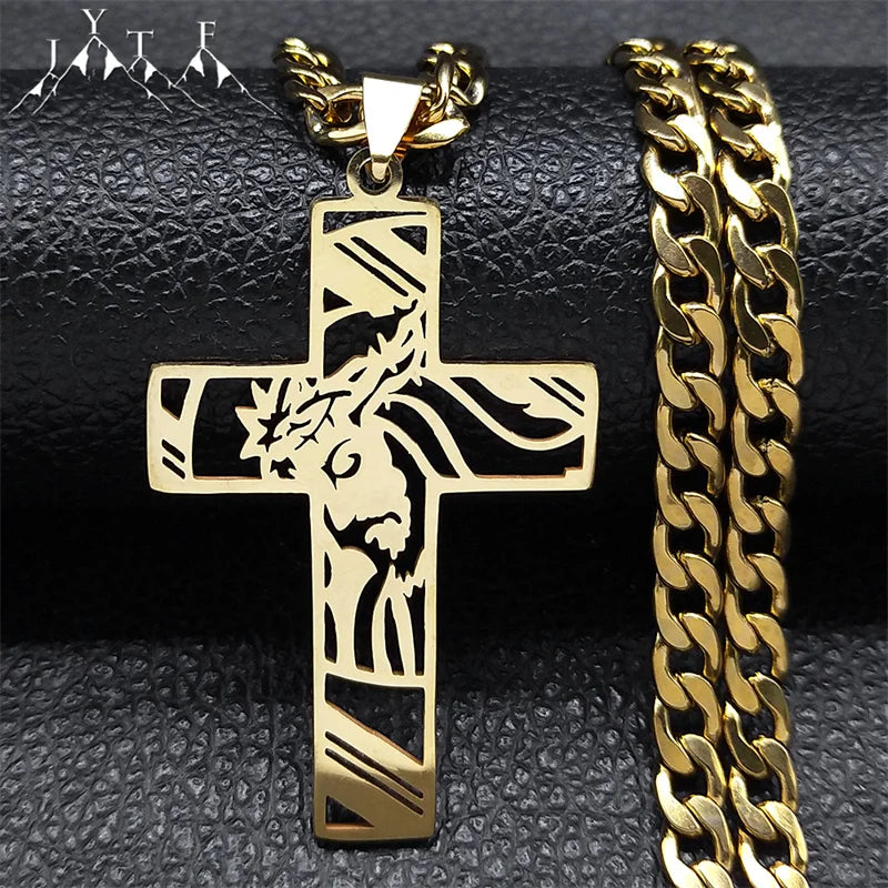 Gold-tone stainless steel Jesus cross pendant with crown of thorns beside a curb chain on black leather