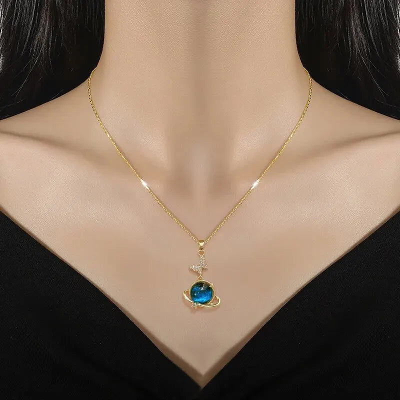 Woman wearing the gold-tone planet pendant necklace with a black top
