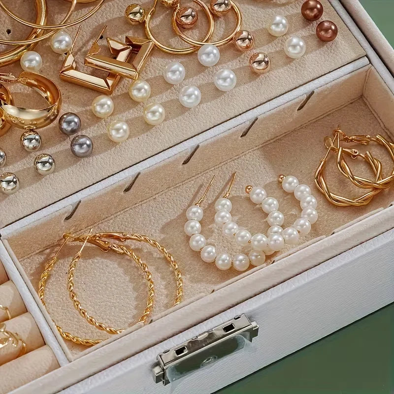 Faux pearl stud earrings, pearl hoops and twisted gold hoop earrings in a jewelry box