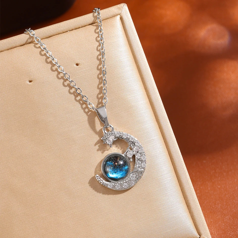 Close-up of the silver-tone crescent moon pendant with a blue planet stone