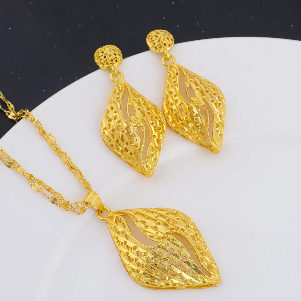 Close-up of gold plated leaf drop earrings and pendant necklace set