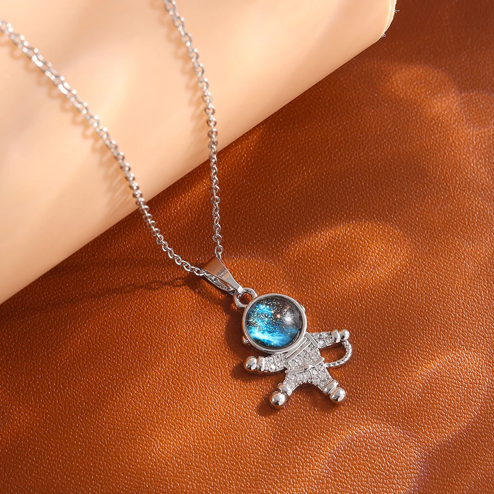 Silver-tone astronaut pendant necklace with a blue planet stone