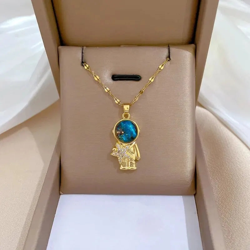 Gold-tone astronaut pendant necklace displayed inside an open gift box