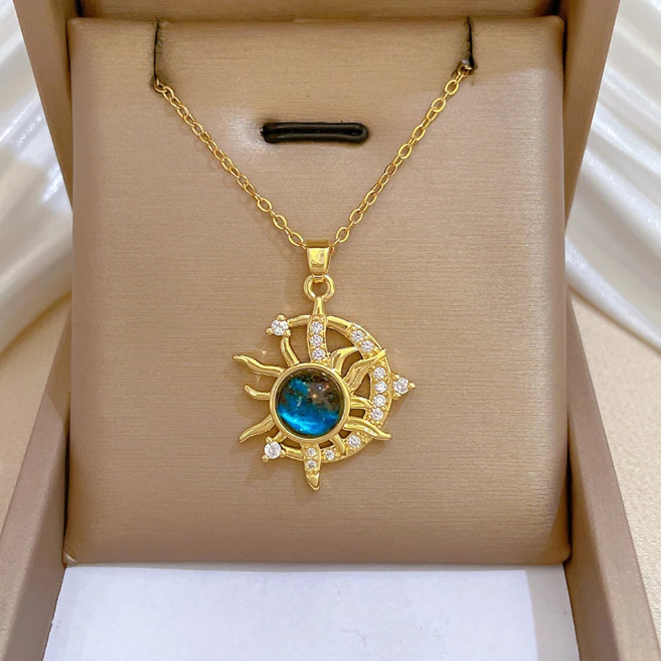 Gold-tone sun burst pendant necklace with a blue planet stone in a gift box