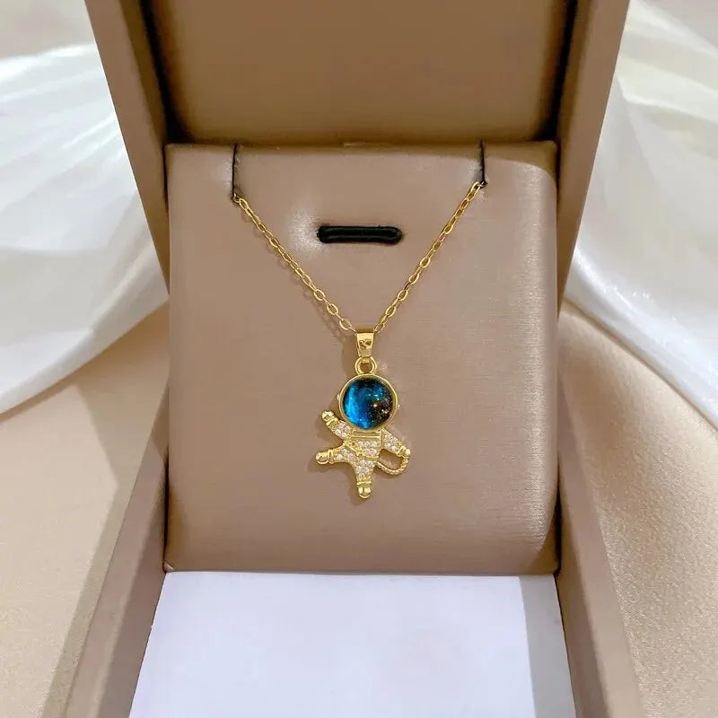 Gold-tone astronaut charm necklace with a blue planet bead in a gift box