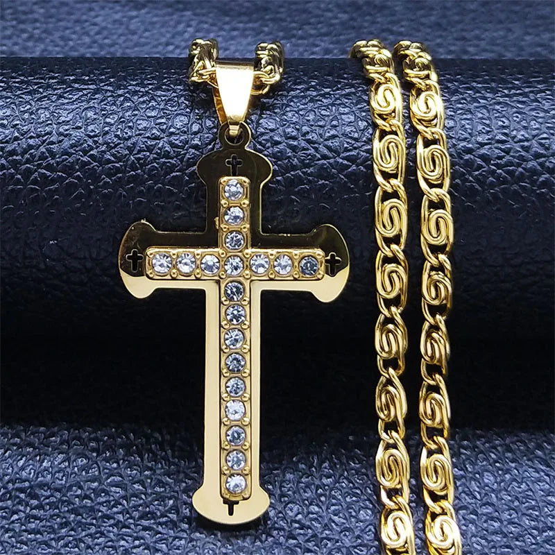 Gold cross pendant necklace with crystal stones on a blue background