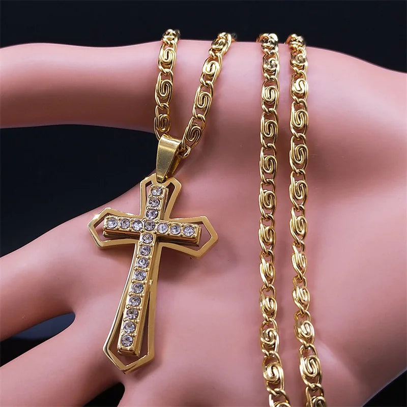 Men's gold cross pendant necklace with matching gold chain held in hand