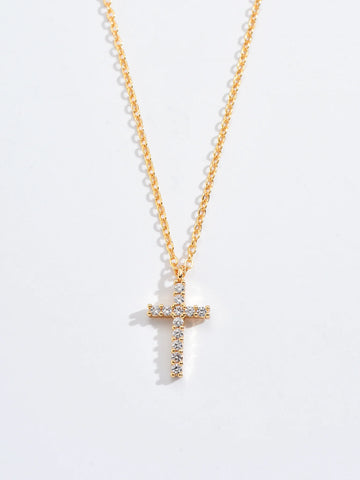 Macro view of the gold-tone cross pendant showing the pave-set zircon stones