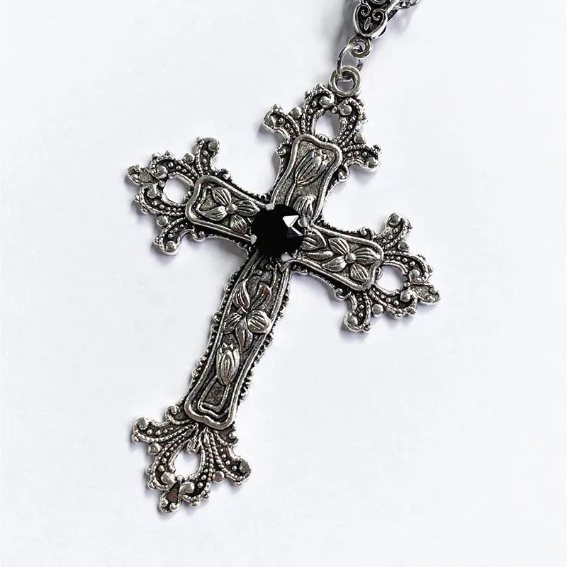 Close up of the large silver baroque cross pendant with a faceted black center stone