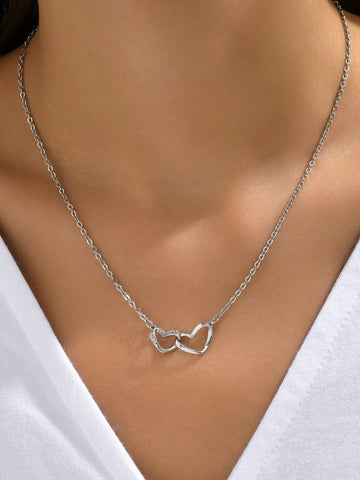 Silver-tone version of the double heart necklace worn with a white V-neck top